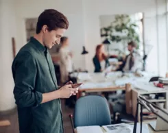 Man checking his mobile phone at the office